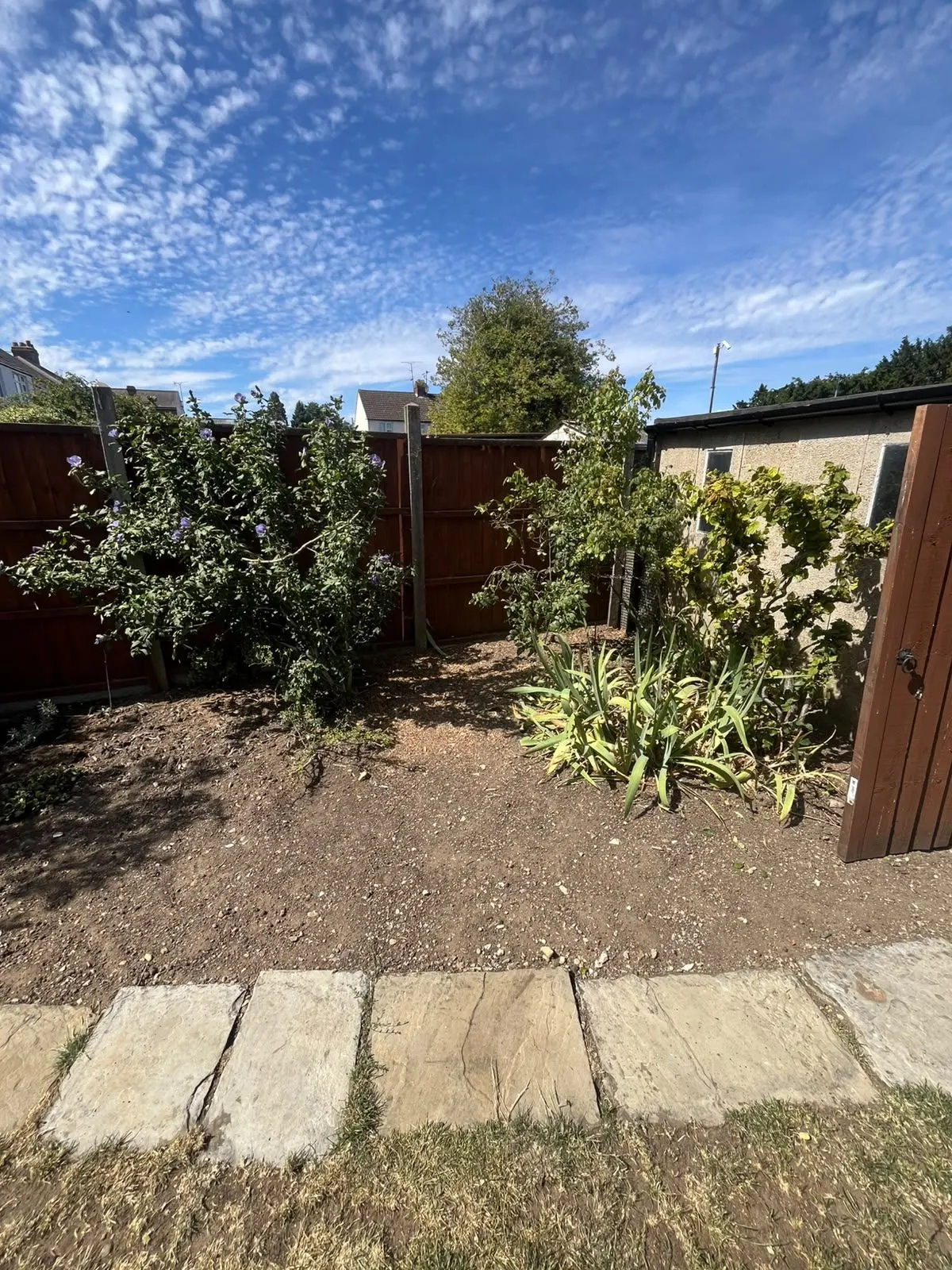 The same planting bed and timber gate after the tree was removed